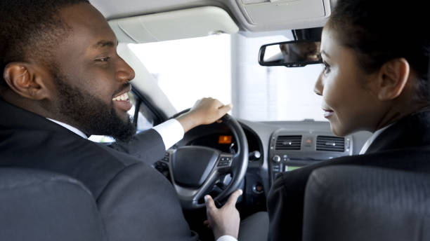 istock Two multi-ethnic colleagues flirting, discussing business in car, having affair 975785718