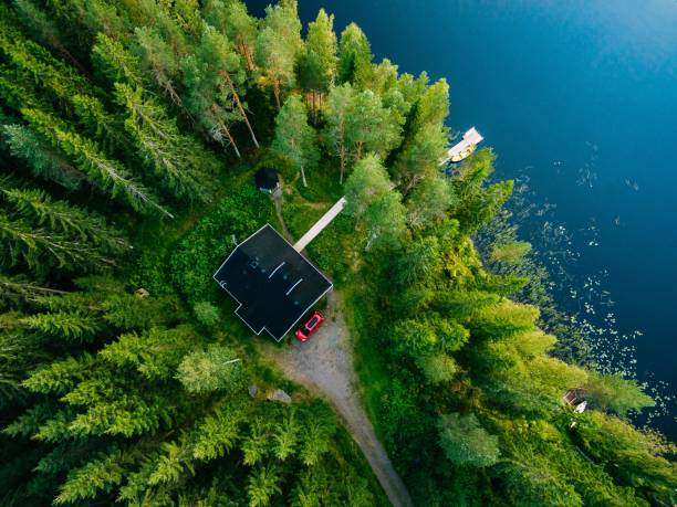 vista aérea de casa de madera en bosque verde en el lago azul en verano rural finlandia - above horizontal wood house fotografías e imágenes de stock