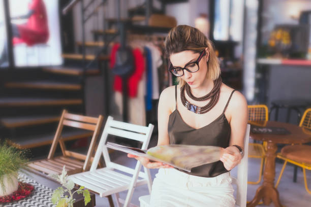 Modern woman reading magazine in cafe
