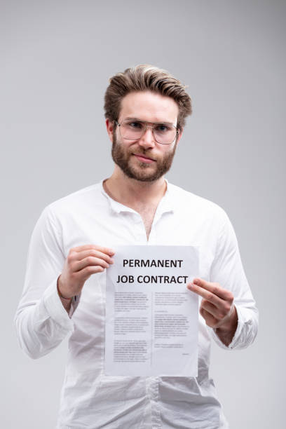 istock Attractive bearded man holding up a job contract 975796104