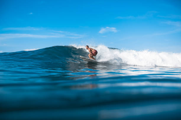 istock young sporty man having fun on surfboard on sunny day 975798242