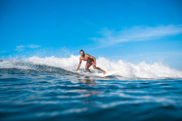 istock handsome sporty man surfing on sunny day 975798448