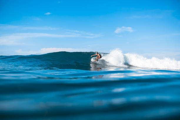 istock young sporty man riding on waves on sunny day in ocean 975798940