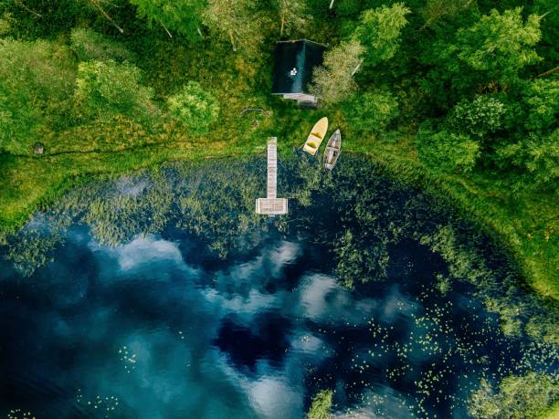 aerial view of sauna house by the lake shore. wooden pier with fishing boats. - finland sauna lake house imagens e fotografias de stock