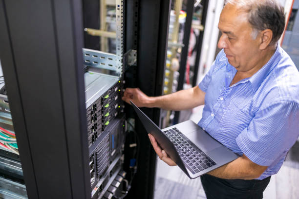 Senior engineer checking the system in the server room stock photo