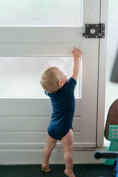 istock Baby boy tries to unlock the door 975808214