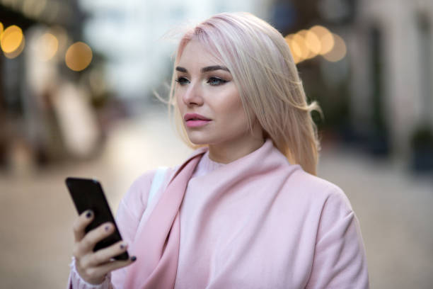 istock Beautiful young woman in real life using smartphone 975813780