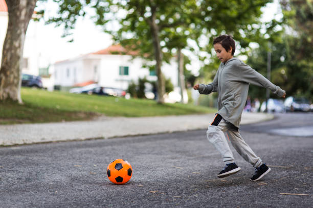 istock Boy play with football ball 975814624