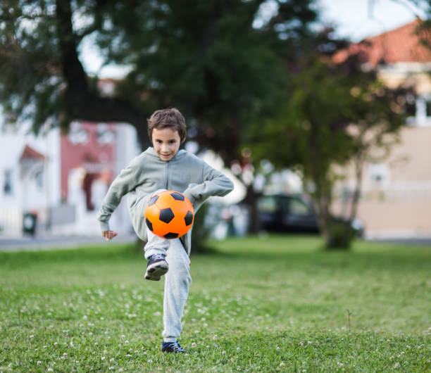 istock Boy play with football ball 975814764