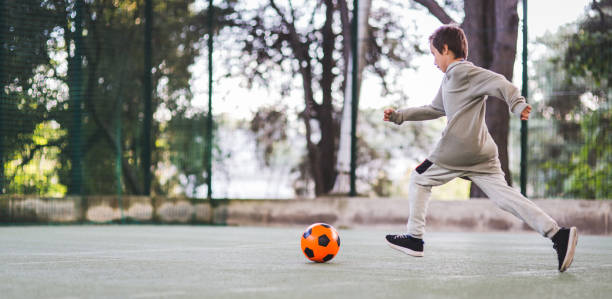 istock Boy play with football ball 975814912