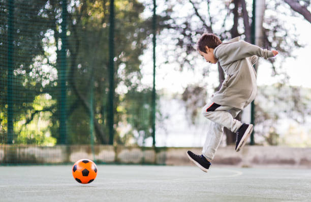 istock Boy play with football ball 975814974