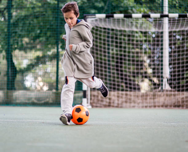 istock Boy play with football ball 975815066