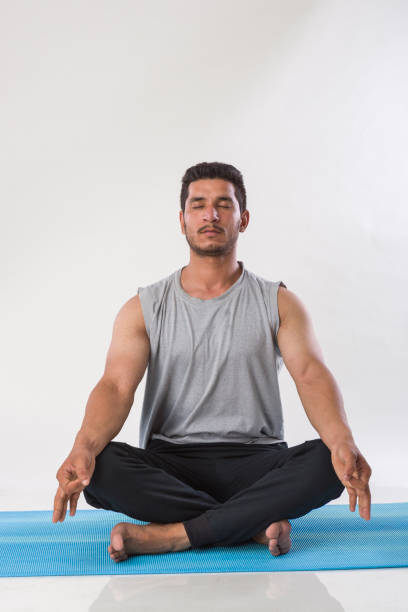istock young indian man practising yoga indoor 975821286
