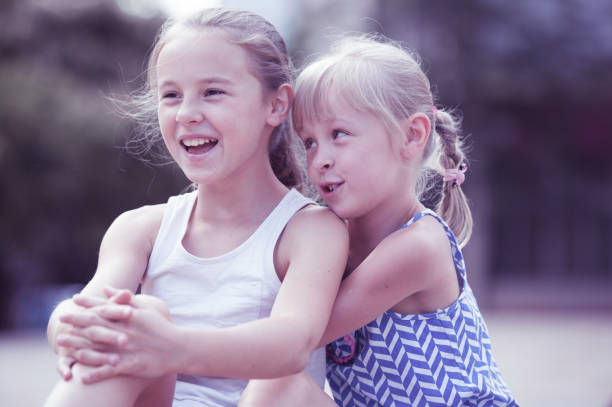 istock Two smiling little girls embracing 975845506