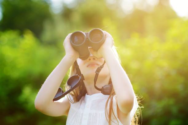 istock Funny little girl looking through binoculars 975867262