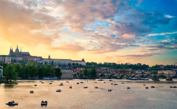 Beautiful view of the Prague castle complex with the Saint Vitus Cathedral and the Charles bridge on a cloudy sky at sunset. Largest ancient castle in the world with gothic style church over the Vltava river