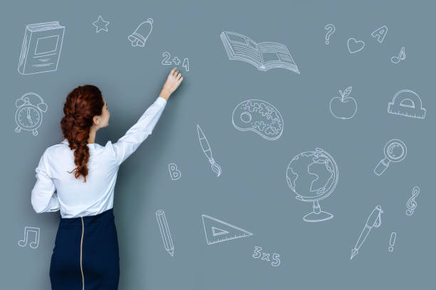 istock Clever teacher explaining a new topic and writing on the blackboard 975874206