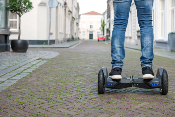 Modern technology, a man is riding on a blackboard. Close Up of Dual Wheel Self Balancing Electric Skateboard Smart. on electrical scooter outdoors. Copy space Modern technology, a man is riding on a blackboard. Close Up of Dual Wheel Self Balancing Electric Skateboard Smart. on electrical scooter outdoors. Copy space. hoverboard stock pictures, royalty-free photos & images