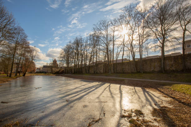 lunghe ombre sulla superficie dell'acqua ghiacciata - winter city germany brandenburg foto e immagini stock