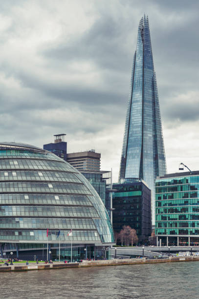 the curved glass building in spherical shape of the city hall of london and the shard, the tallest building in the uk, iconic architectural landmarks of london located on the southwark bank of the river thames near tower bridge, england - tower london england greater london inner london imagens e fotografias de stock