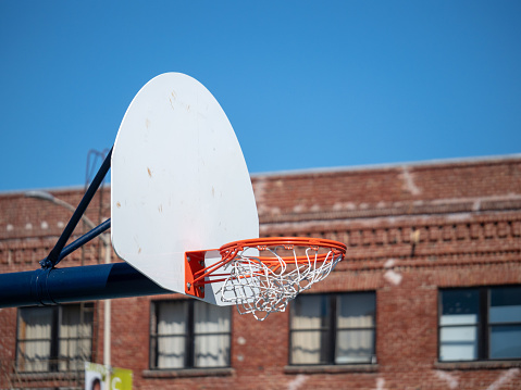 An outdoor basketball hoop with the net swishing after a made shot