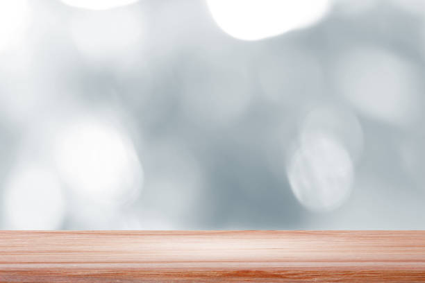 istock empty wooden on white blurred nature backdrop. Wood table top. can used for display or montage your products 975904464