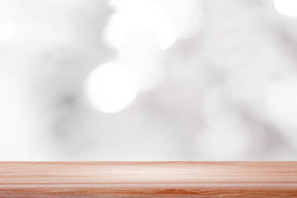 istock empty wooden on white blurred nature backdrop. Wood table top. can used for display or montage your products 975904792