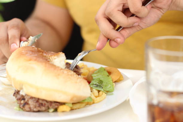 istock Young man eating an Hamburger 975912512