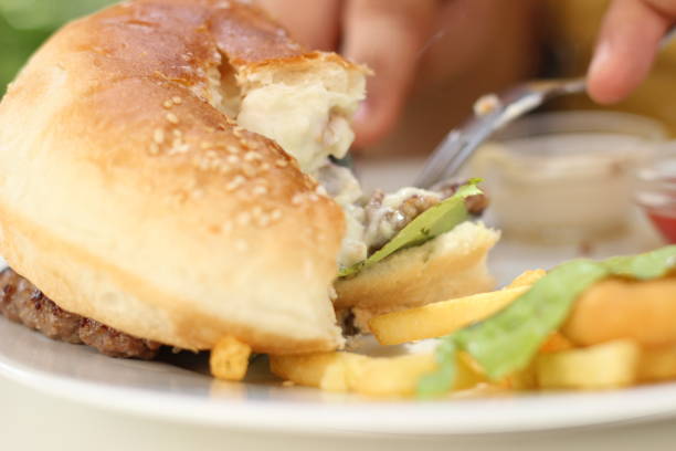 istock Young man eating an Hamburger 975912522
