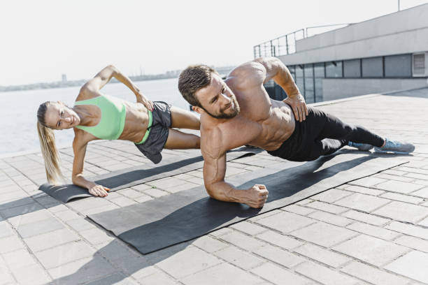 caber a aptidão mulher e homem fazendo exercícios de fitness ao ar livre na cidade - middle human age couple women - fotografias e filmes do acervo