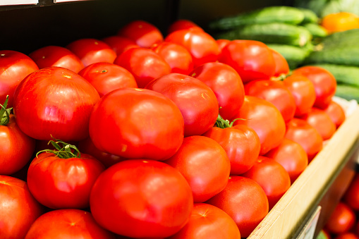 Vegetables are full of vitamins. Fresh and ripe tomatoes in a basket on a supermarket shelf