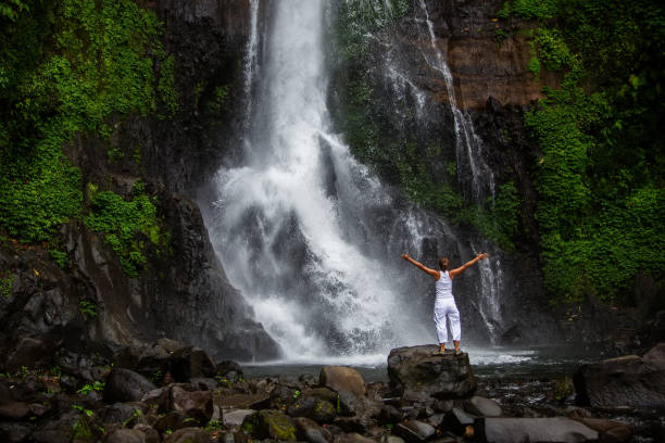 istock Woman practices yoga at Gitgit waterfall on Bali in indonesia 975921866