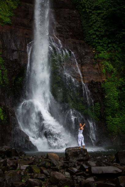 istock Woman posing near Gitgit waterfall on Bali in indonesia 975922130