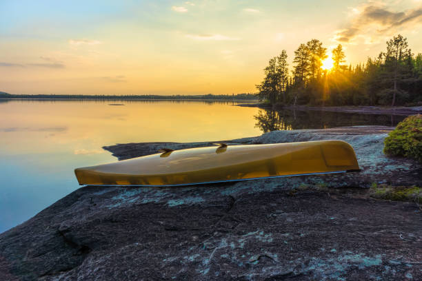 istock Canoe and Lake with sunset reflections in the sky 975922828