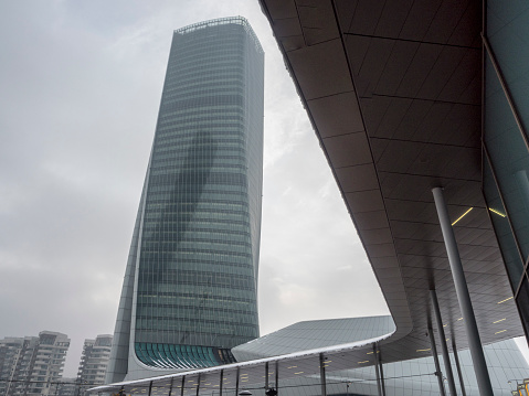 Milan, Italy - March 2, 2018: Milan, Lombardy, Italy: snow in late winter (March) at Citylife. the Hadid tower, or Generali tower.