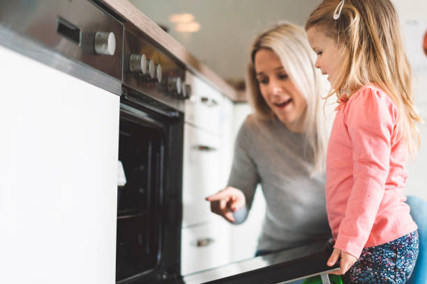 istock Mother and daughter baking cookies 975953584