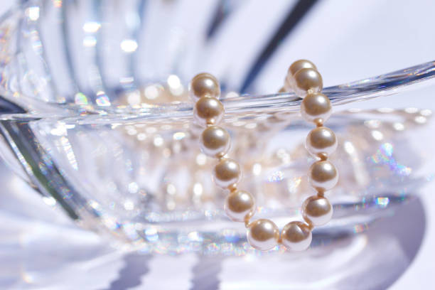Abstract background macro of a beautiful modern lead crystal glass heart bowl and pearls This abstract background features a close-up view of a beautiful modern heart-shaped lead crystal glass bowl accented with a vintage string of pearls. lead cut glass crystal stemware stock pictures, royalty-free photos & images