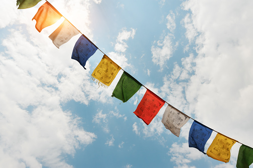 Tibetan flags with mantra on sky background