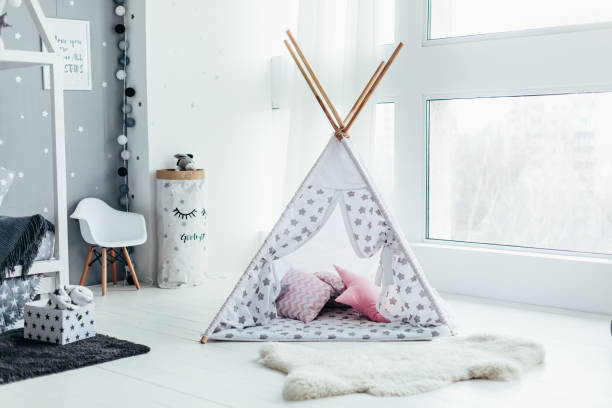 tente pour enfants avec des coussins près de la fenêtre dans le studio, chambre d’enfant, de la fourrure sur le sol. - wigwam photos et images de collection