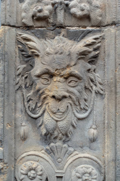 An old man face made of stone built into a wall in Sicily