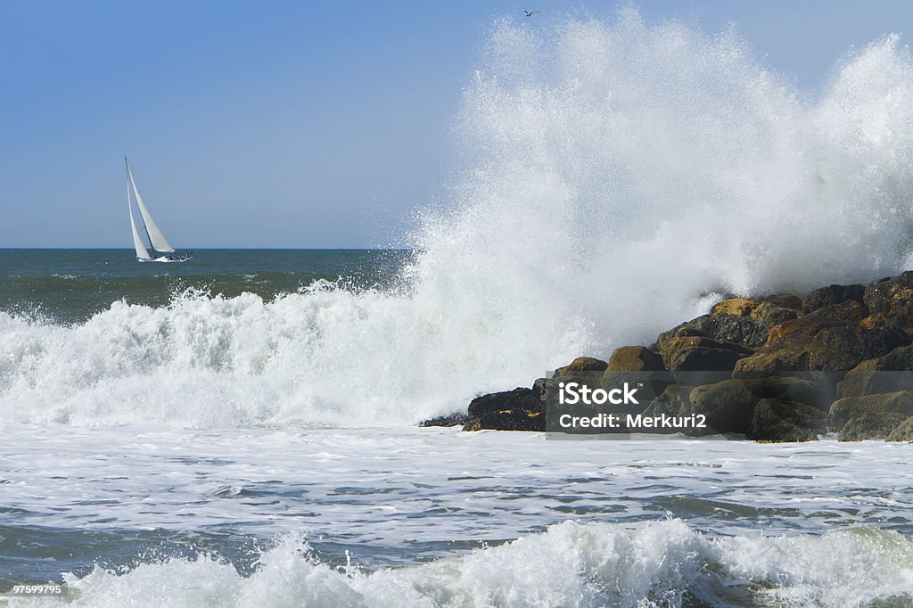 Océan vague se brisant sur la jetée avec voilier - Photo de Activité libre de droits