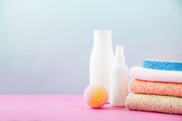 istock bathroom accessories - towels and shampoos,bath foam, cream on a light, bright blue and pink background The concept of caring for yourself, your body. Place for copy space 976016552