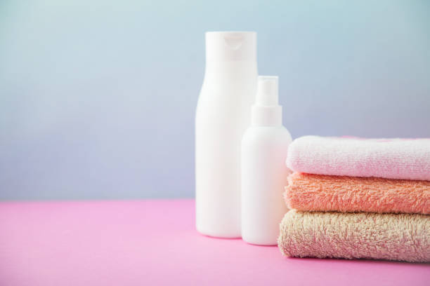 istock bath accessories - towels folded and shampoo , stacked on a light, bright blue and pink background The concept of caring for yourself, your body. Copy space 976016846