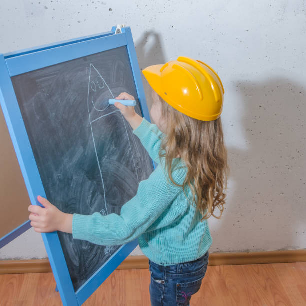 istock girl in a yellow construction helmet 976043880