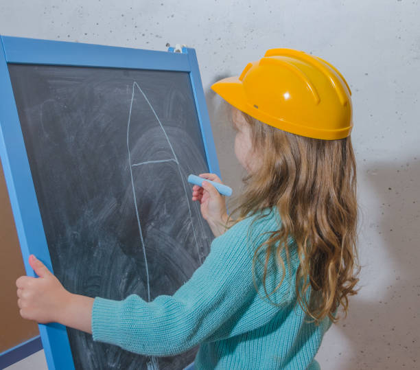 istock girl in a yellow construction helmet 976044126