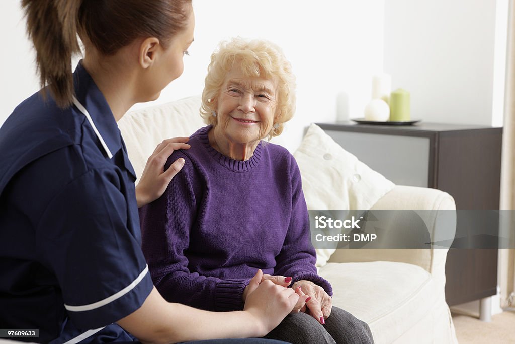 Young nurse assisting a happy senior woman  Adult Stock Photo