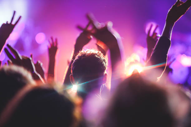 un'affollata sala da concerto con luci da palcoscenico, spettacolo rock, con silhouette di persone - musica popolare foto e immagini stock
