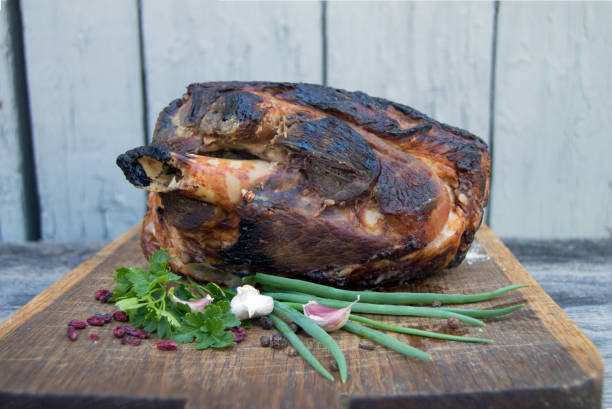 istock baked meat on wooden board with spices and herbs 976103596