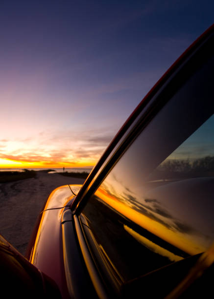 istock Colorful coastal sunrise with car window reflection 976186918