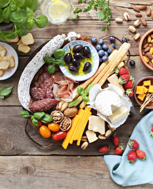 istock Appetizers platter with cheese variety, sausage, olives, nuts and berries. 976187540